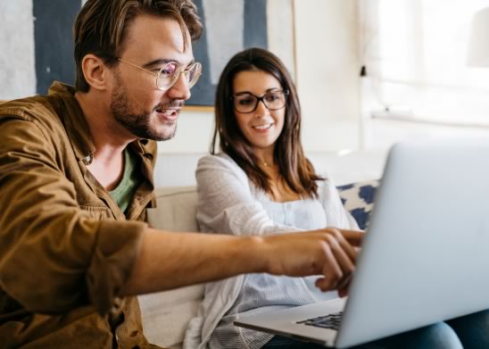 Two people reviewing project details on a laptop