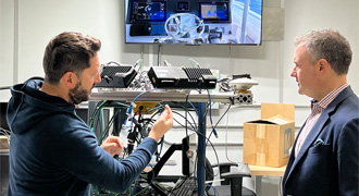 Navy leader discusses tech with business person.